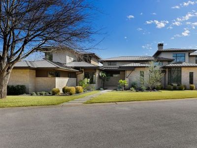 The house has two stories and there is a huge tree in front.